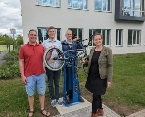 Vier Personen stellen die Fahrrad-Reparaturstation vor