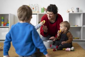 Frau hilft Kleinkindern
