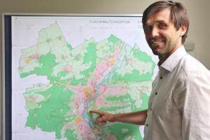 Dezernent Dirk Lange zeigt auf den neuen Flächennutzungsplan der Stadt Jena