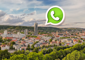 Auf einem Panoramabild der Stadt Jena ist das WhatsAppLogo zu sehen (eine Sprechblase mit Telefonhörer)