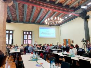 Stadtratsmitglieder sitzen an Tischen im Historischen Rathauses während der Stadtratssitzung