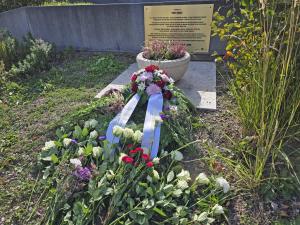 Gedenktafel mit Kranz und Blumen 