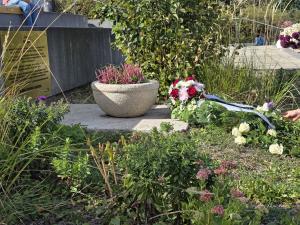 Gedenktafel mit Kranz und Blumen