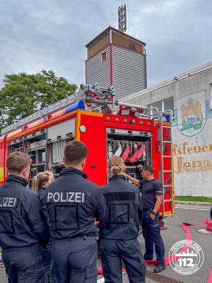 Polizisten im Vordergrund und im Hintergrund digitale Sirene.