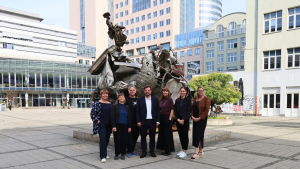 Gruppe von Menschen stehen vor einer Skulptur auf dem Ernst-Abbe-PLatz in Jena.
