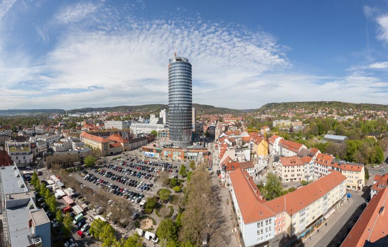 Ein großer Parkplatz mit einem modernen Turm dahinter