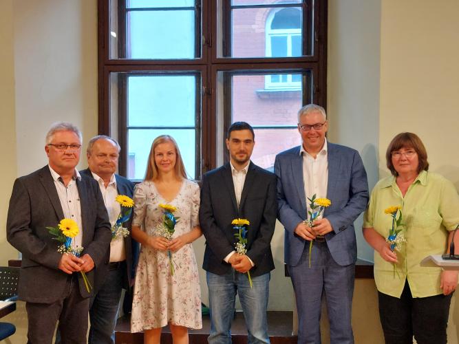 Mitgleder der AFD-Fraktion stehen im Rathaus vor einem Fenster