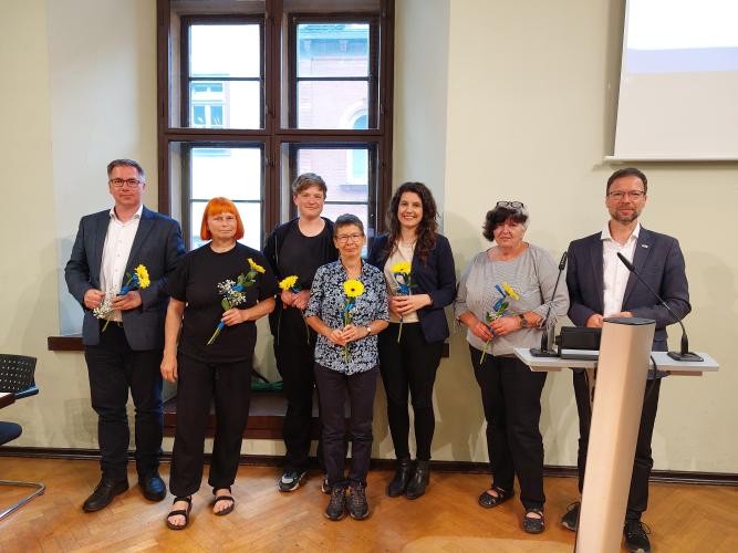 Mitglieder der Fraktion DIE LINKE stehen im Rathaus vor einem Fenster