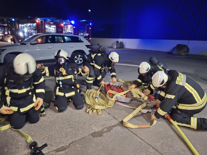 Mehrere Feuerwehrleute sortieren Schlauch