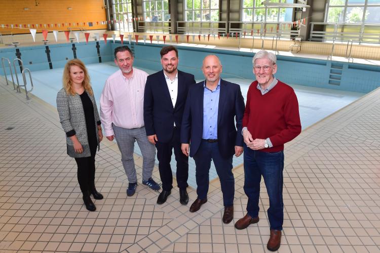 Stehen vor dem leeren Schwimmbecken in der ehemaligen Schwimmhalle: Katrin Hitziggrad (Blank – Agentur für Zwischennutzung), Jörg Hühn (Geschäftsführer reCoVer Stiftung Jena), Dezernent Johannes Schleußner, Bernhard Dengel (Geschäftsführer Jenaer Bäder) und Ortsteilbürgermeister Volker Blumentritt (v. l.)
