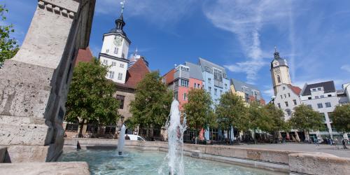 Ein Brunnen im Hintergrund Häuser auf dem Jenaer Markt