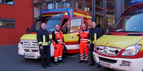 Vier Männer an zwei Fahrzeugen 