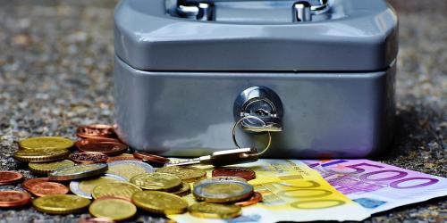 Geldkassette davor leigen Münzen und Scheine