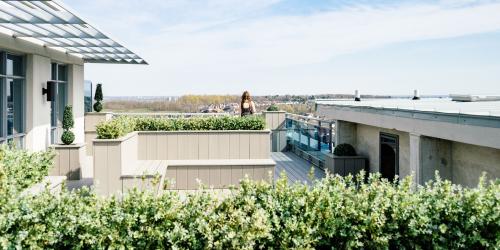 Blick über eine grüne Terasse, im Hintergund eine Landschaft mit Gebäuden