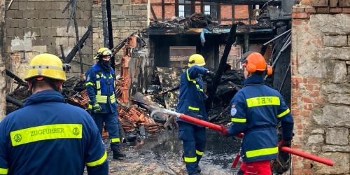 Feuerwehrmänner vor einem zerstörten Gebäude