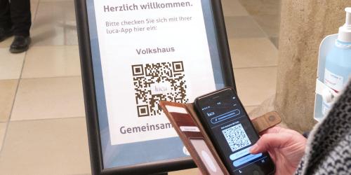 Eine Person hält ein Handy an einen Barcode