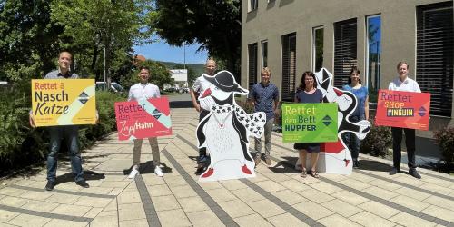 Eine Gruppe mit Menschen haben bunte Plakate in der Hand