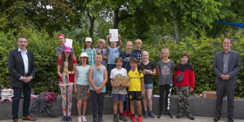 Viele Kinder und zwei Männer lachen in die Kamera