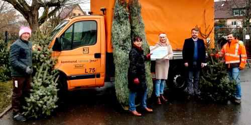 Fünf Menschen halten Weihnachtsbäume