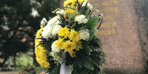 Ein Gedenkkranz vor einem Denkmal