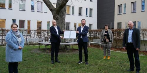 Ein Gruppenbild aller Unterzeichner der Kooperationsvereinbarung unter der Eiche vor dem Rathaus,