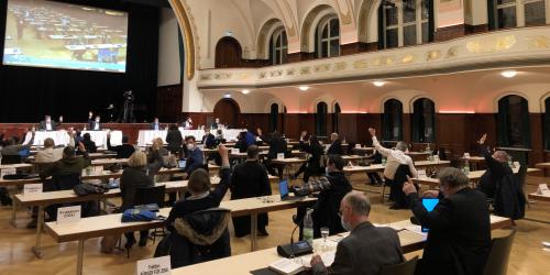 Ein großer Saal mit Menschen am Tisch