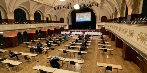 Ein großer Saal mit Menschen am Tisch