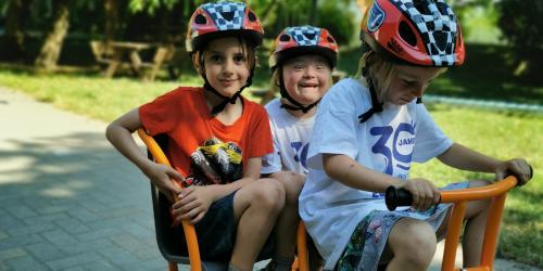 Drei Kinder auf einem Tretfahrzeug