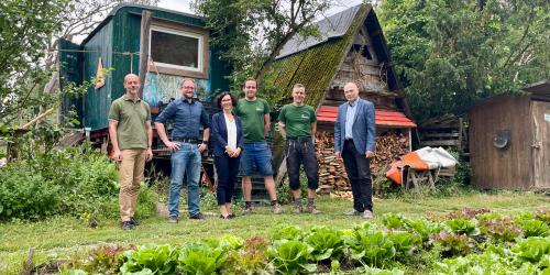 Sechs Menschen hinter einem Beet