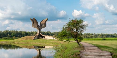 Eine Landschaft mit einem Denkmal, welches sich in den Himmel öffnet