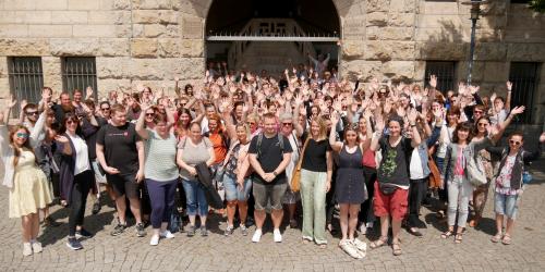 Viele Menschen winken in die Kamera