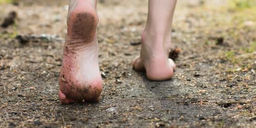 Kinderfüße laufen über Erde.