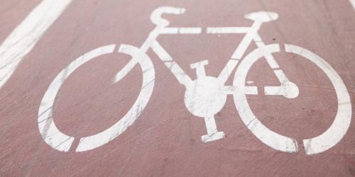 Weißes Fahrradsymbol auf roter Straße