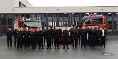 Viele Feuerwehrmänner schauen in die Kamera.