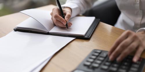 Hand schreibt auf Block