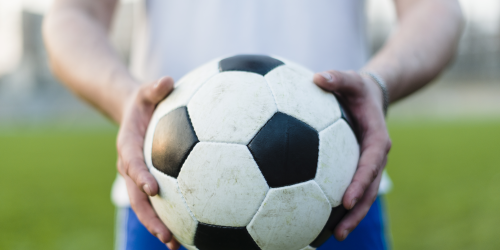 Fußball der in zwei Händen gehalten wird