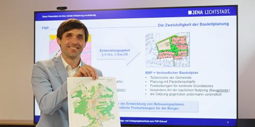 Mann hält eine Landkarte in die Kamera.