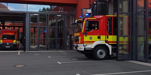 Feuerwehrauto fährt aus dem Gerätehaus.