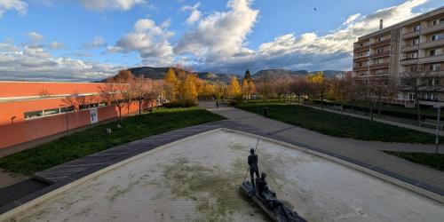 Blick auf einen Brunnen mit umliegenden Gebäuden.