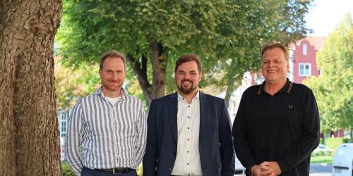 Drei Personen stehen nebeneinander