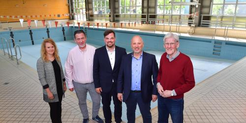 Stehen vor dem leeren Schwimmbecken in der ehemaligen Schwimmhalle: Katrin Hitziggrad (Blank – Agentur für Zwischennutzung), Jörg Hühn (Geschäftsführer reCoVer Stiftung Jena), Dezernent Johannes Schleußner, Bernhard Dengel (Geschäftsführer Jenaer Bäder) und Ortsteilbürgermeister Volker Blumentritt (v. l.)