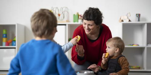 Frau hilft Kleinkindern