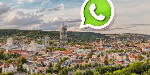 Auf einem Panoramabild der Stadt Jena ist das WhatsAppLogo zu sehen (eine Sprechblase mit Telefonhörer)