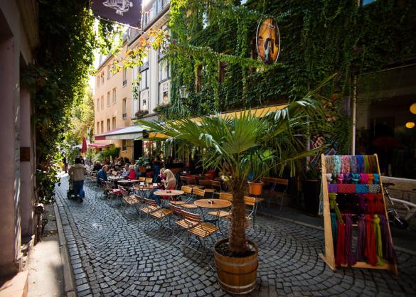 Blick in eine Gasse mit Lokalen und vielen Sitzplätzen