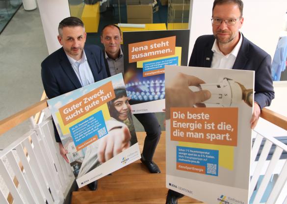 V.l.n.r.: Stadtwerke-Geschäftsführer Gunar Schmidt, Christian Gerlitz, Leiter des kommunalen Energiekrisenstabs, und Jenas Oberbürgermeister Thomas Nitzsche präsentieren drei Motive der gemeinsamen Energiesparkampagne unter dem Motto „Jena steht zusammen“.