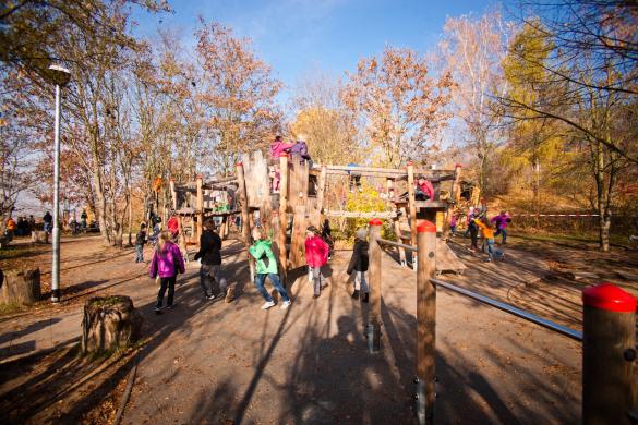 Spielende Kinder auf einem Pausenhof mit Spiel- und Sportgeräten