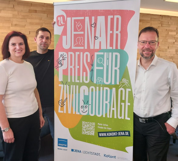 Drei Personen neben einem Roll-up.