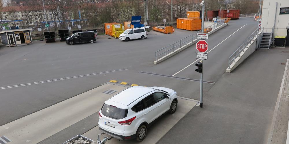 Ein Auto auf einem großen Hof mit vielen Containern