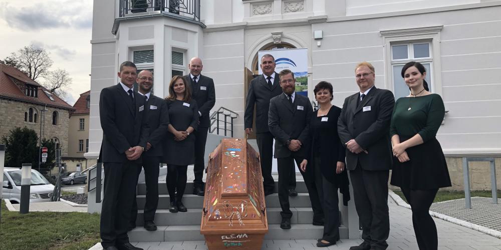 Menschen umringen einen Sarg