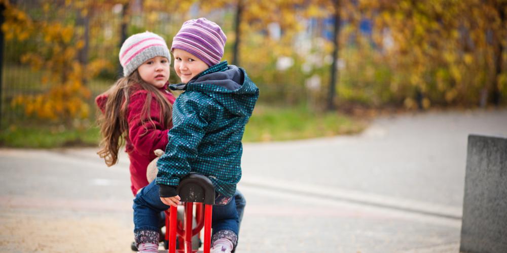 Zwei Kinder auf einem Roller